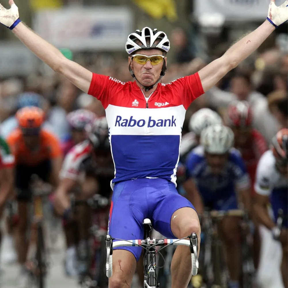 Erik Dekker juicht met zijn armen omhoog als winnaar van een wielerkoers