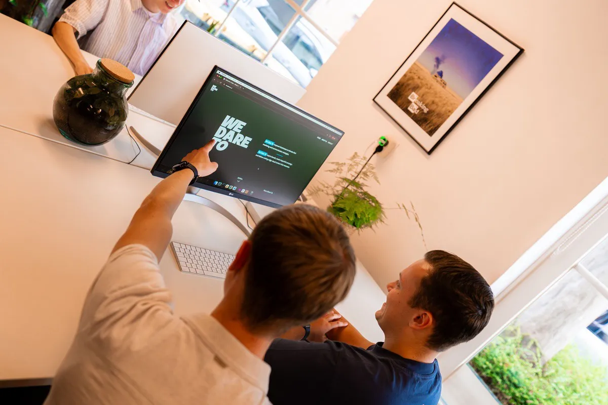 Twee collega’s van Pink Raven bespreken verbeteringen aan een website